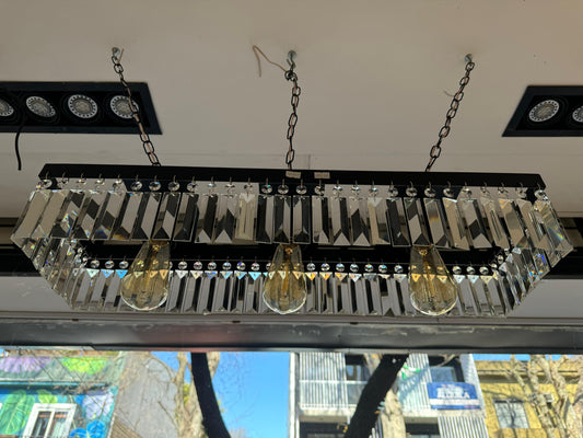 Araña colgante Victoria con estructura rectangular negra y detalles en cristal.