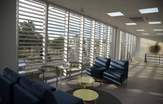 Espacio de espera de banco en Chaco ambientado con sillones Edlyn azules, mesas auxiliares redondas y decoración moderna con iluminación azul.