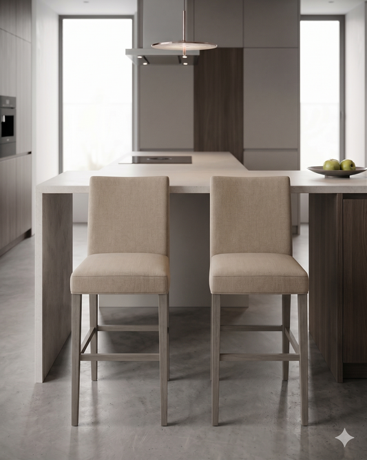 Banqueta alta de diseño contemporáneo con estructura de madera maciza en acabado natural. Presenta un asiento y respaldo integrado, tapizado en pana color claro con textura sutil. Incluye apoyapiés perimetral de madera para mayor estabilidad y confort
