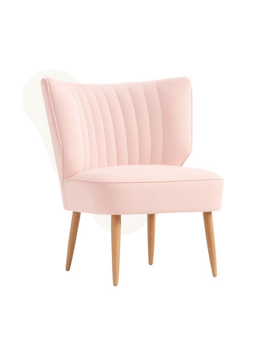 Sillón tapizado en rosa con respaldo curvo acanalado y patas de madera clara. Perfecto para espacios infantiles o rincones de lectura.