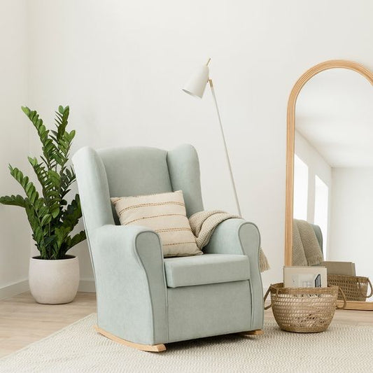 Mecedora verde agua con base de madera en espacio decorado con estilo escandinavo.