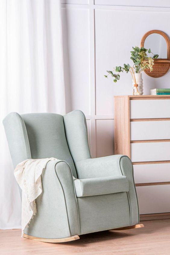 Mecedora verde agua con base de madera en espacio decorado con estilo escandinavo.