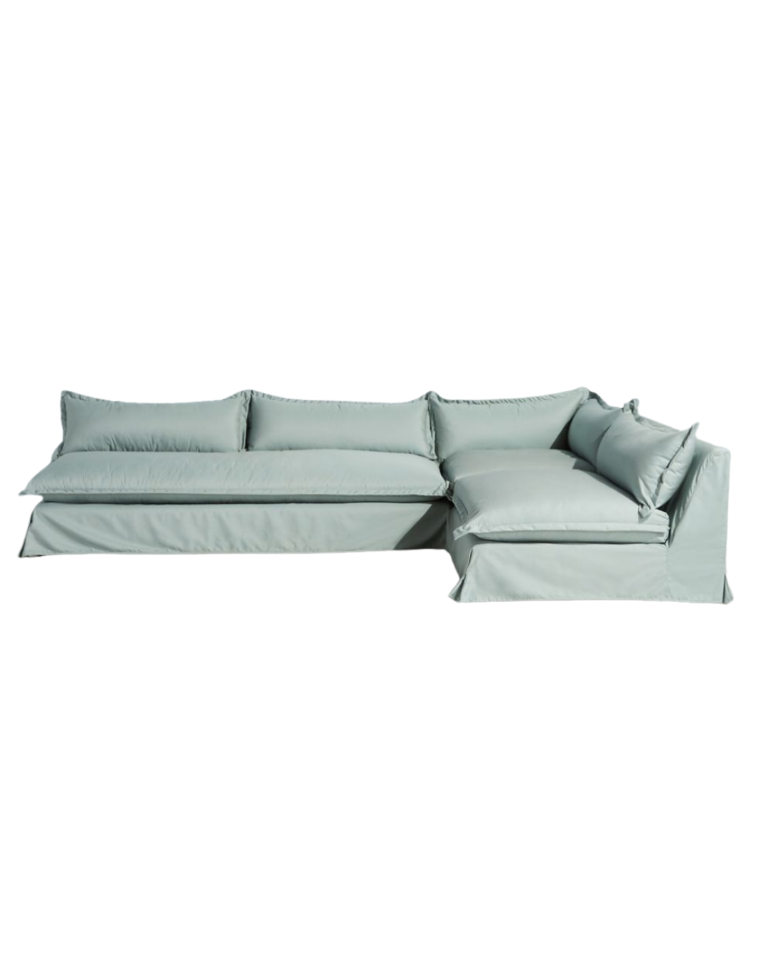 Sillón esquinero grande en lino gris claro con respaldo bajo, almohadones sueltos y chaise longue. Diseño descontracturado y moderno.