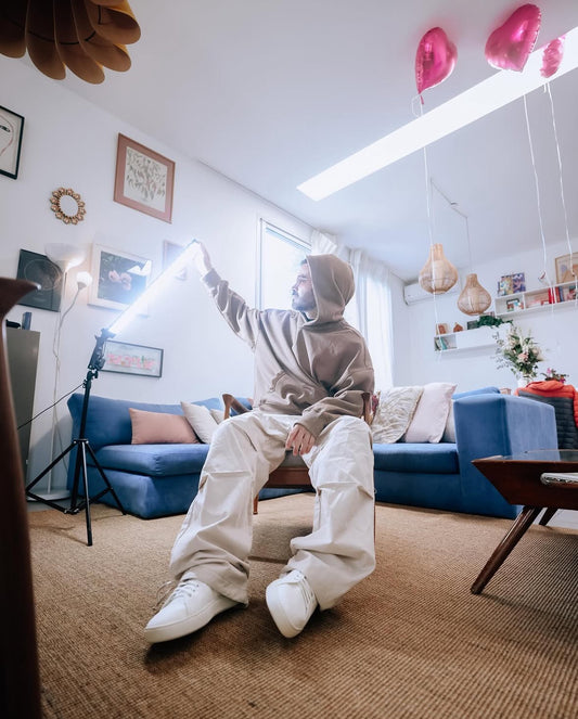 Un sillón esquinero tapizado en pana azul, con múltiples almohadones en tonos claros y pasteles, ubicado en un living moderno con decoración cálida y luminosa