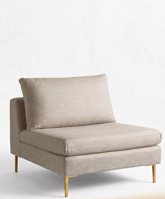 Módulo de sillón sin apoyabrazos en color crema, con respaldo alto y almohadón mullido, patas metálicas delgadas en tono dorado, sobre fondo blanco.
