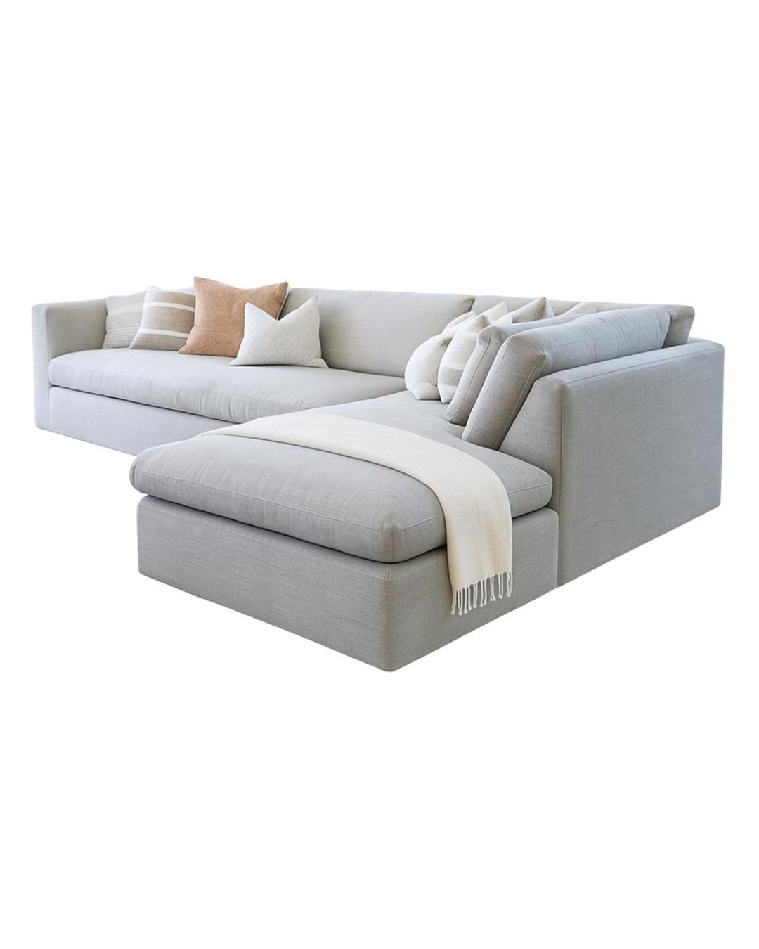 Sillón esquinero en tonos gris perla con chaise longue, almohadones mullidos y manta decorativa. Diseño acogedor y moderno.