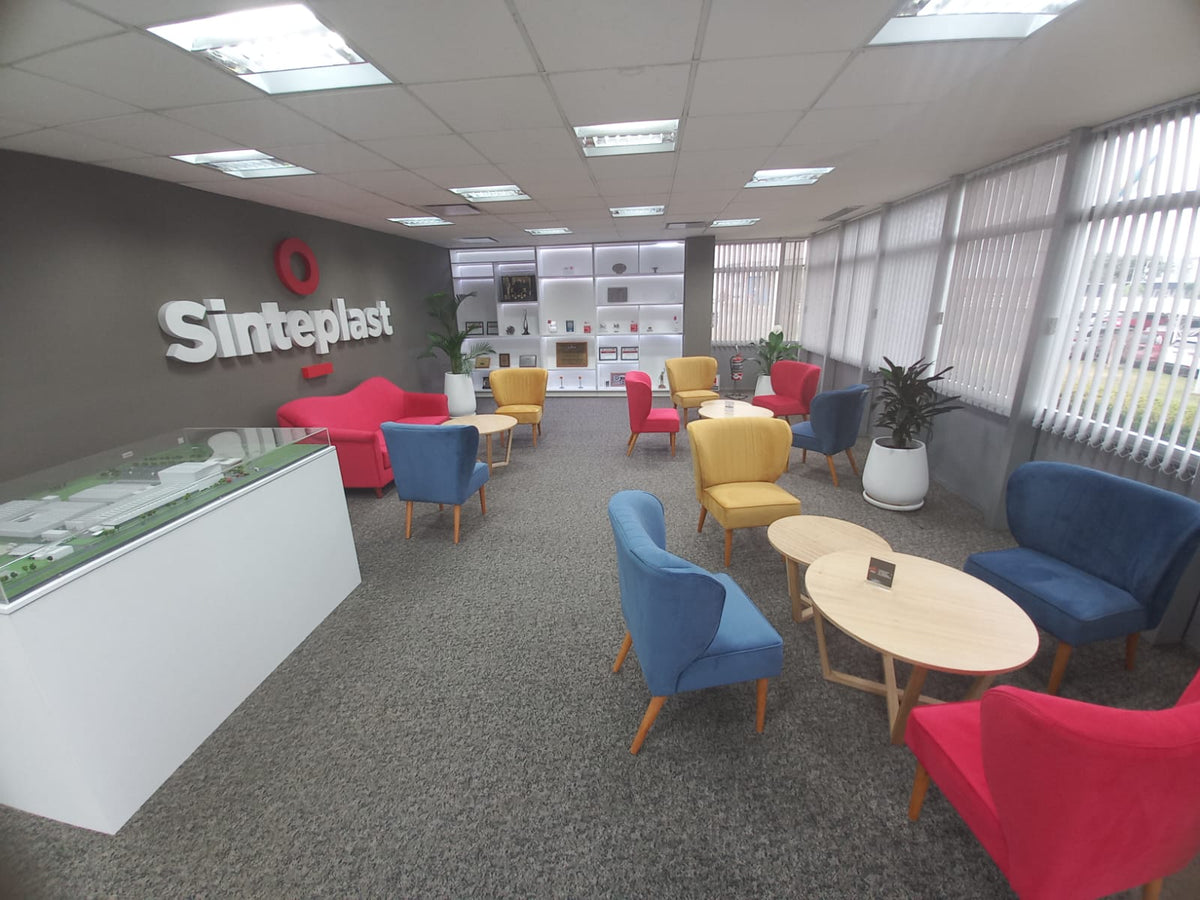 Área de espera de Sinteplast con el Sofá Flower fucsia, un sofá Tita azul de dos cuerpos, mesas ratonas redondas y Sillones Matero Tita de colores