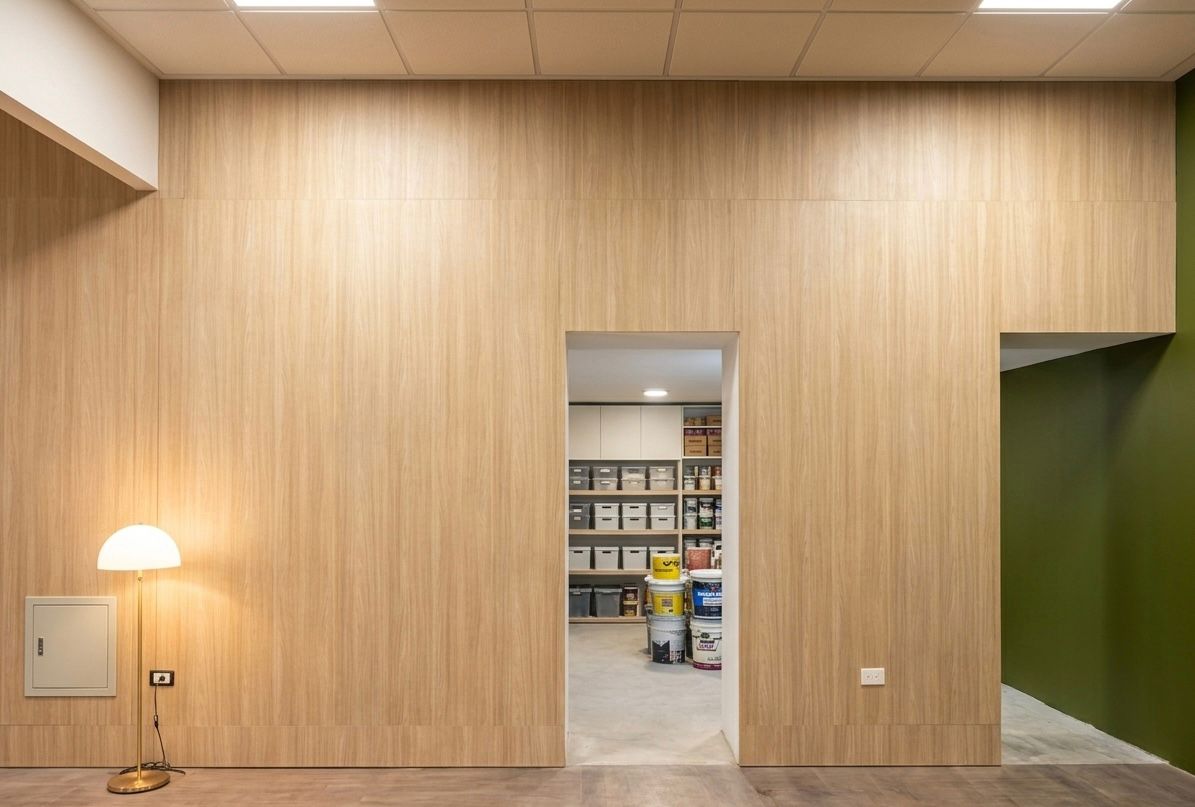 Detalle del revestimiento de madera clara con las puertas de servicio integradas en las oficinas del Banco del Chaco