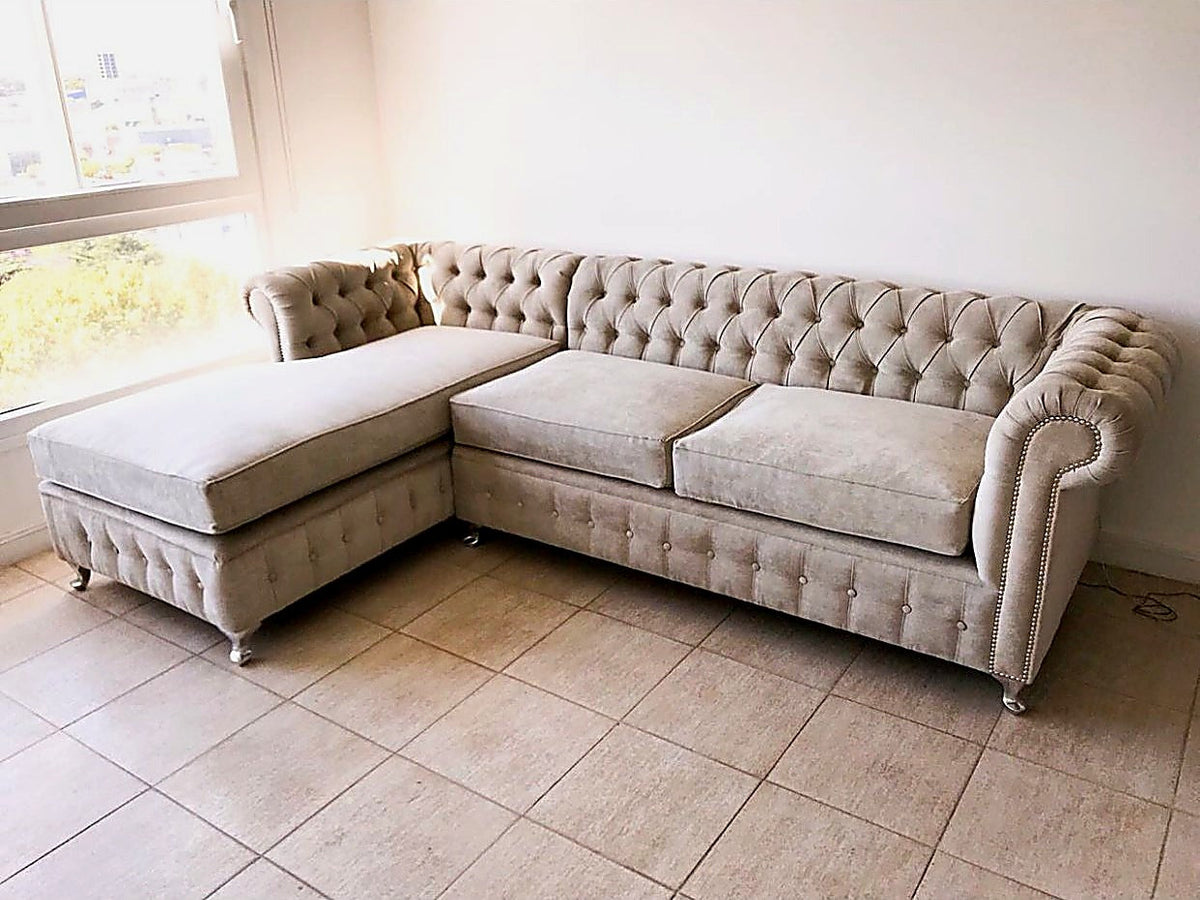 Vista lateral del Esquinero Chesterfield beige de María Martha, con brazo enrollado, tachas y patas plateadas