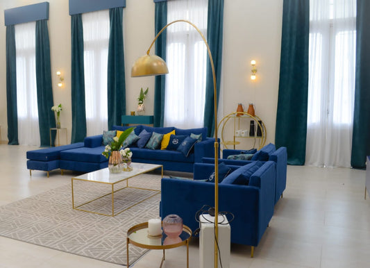 Esquinero Magnolia azul y Sillones Ristretto azules en El Hotel de los Famosos 2022, junto a una lámpara de arco dorada
