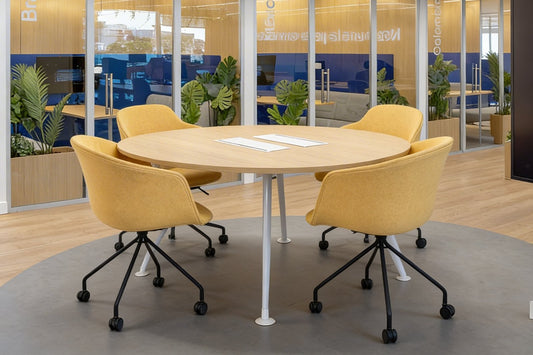 Mesa de reunión Avant de Archivos Activos redonda de madera clara con sillas amarillas