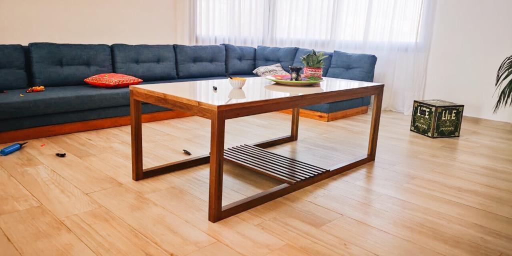 Sillón Esquinero Cardiff azul marino con botoné en el respaldo, en el living de Gastón en Belgrano