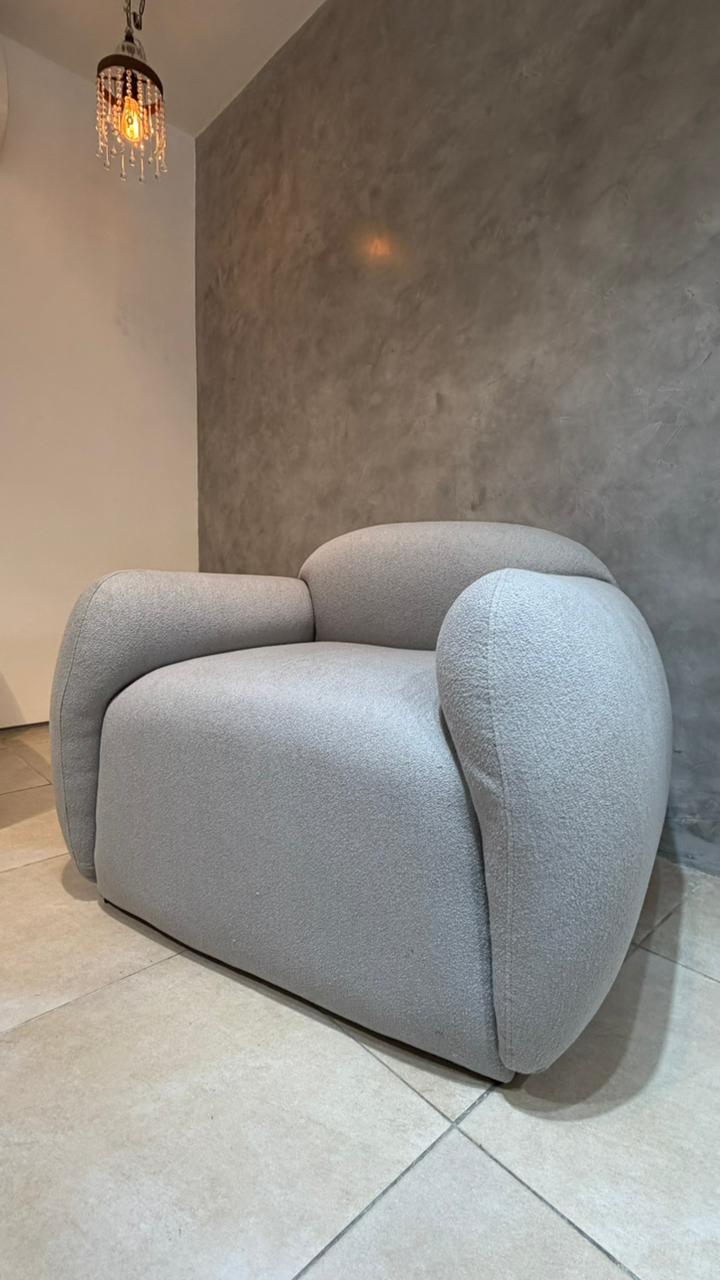 Sillón Cabsha de bouclé gris perla con formas curvas, en stock con entrega inmediata