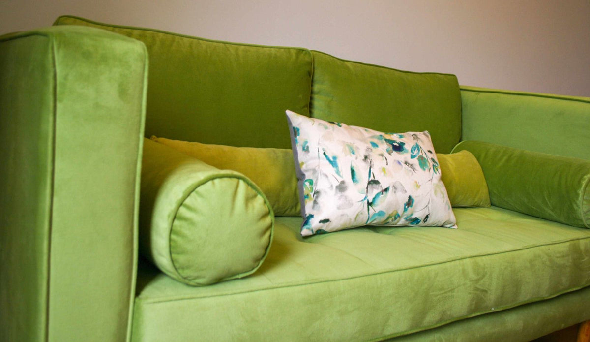 Detalle del asiento botoné y los almohadones cilíndricos del Sofá Bambú verde lima de Ayelén