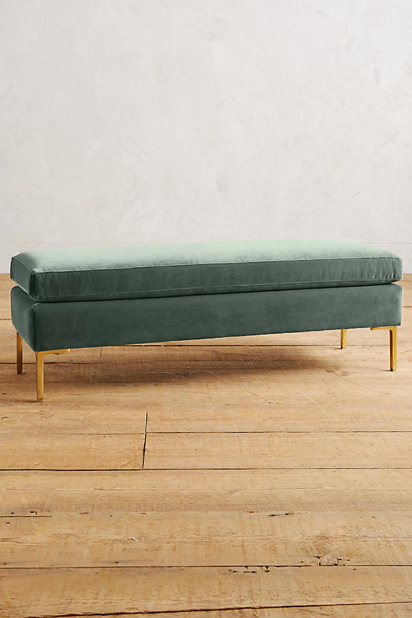 Banqueta de diseño moderno tapizada en verde con patas metálicas doradas. Ideal para pie de cama, recibidores o livings.