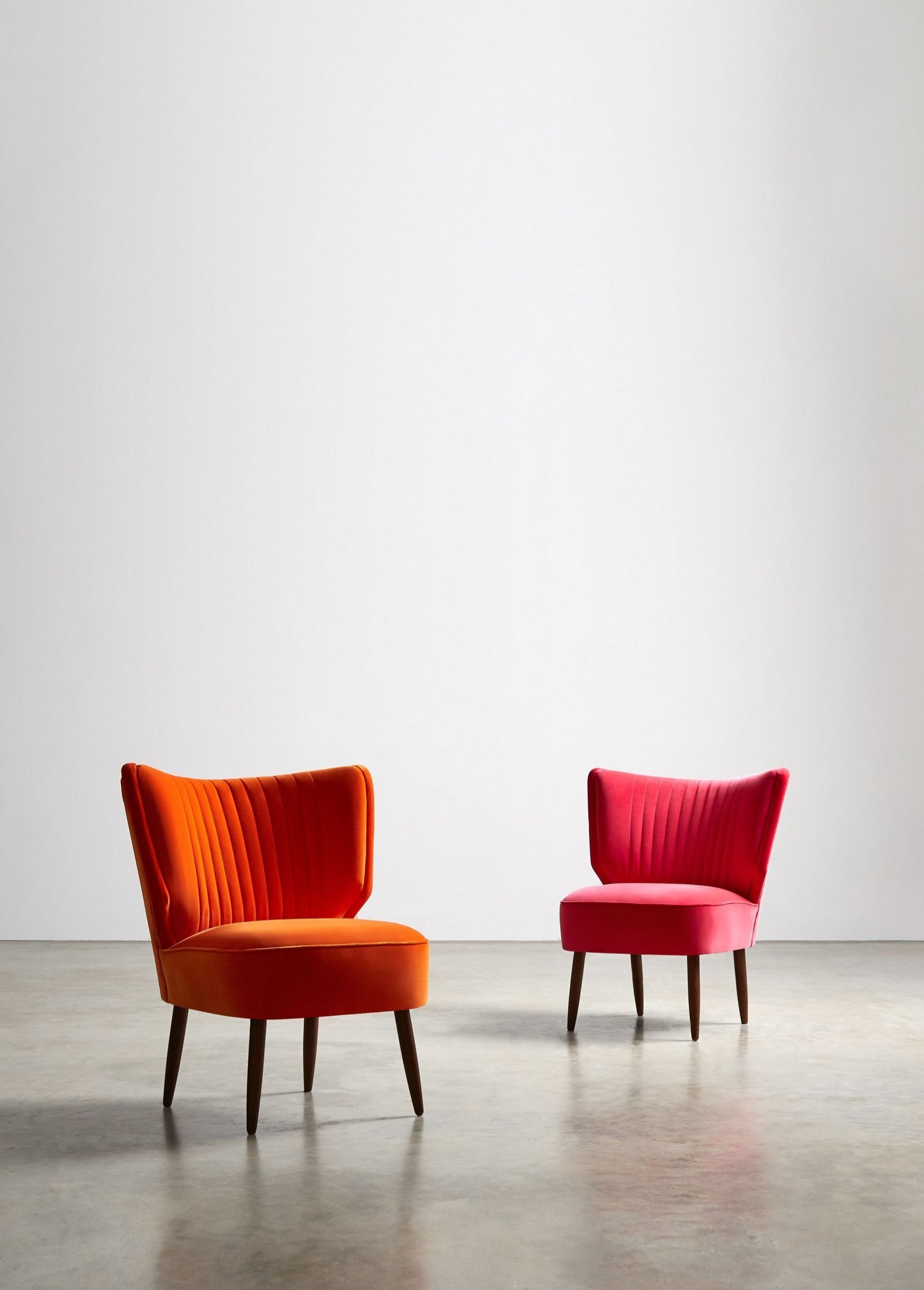 Sillones materos con franjas verticales en el respaldo, rojo anaranjado y fucsia, con patas de madera lustre roble oscuro