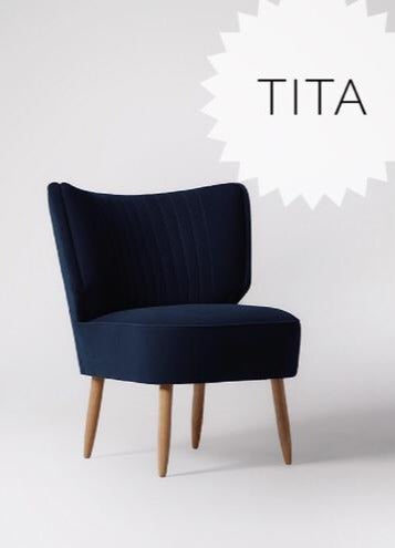 Sillón tapizado en azul con respaldo curvo acanalado y patas de madera clara. Perfecto para espacios infantiles o rincones de lectura.