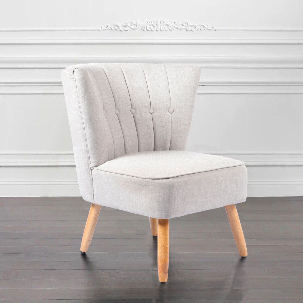 Butaca pequeña tapizada en blanco con respaldo vertical y patas cónicas. Diseño minimalista ideal para niños o espacios reducidos.