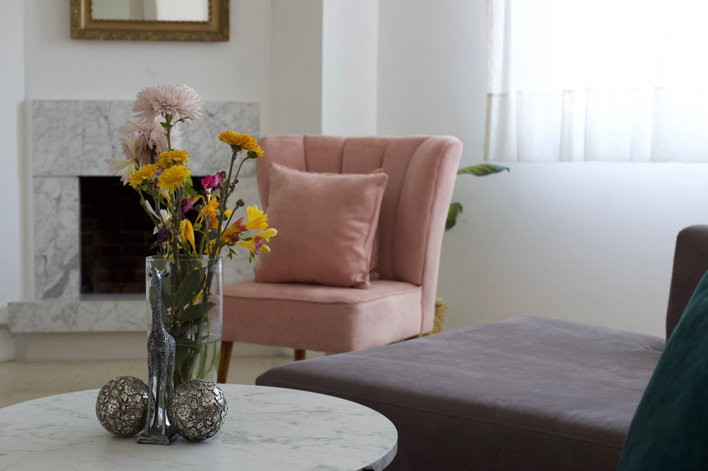 Butaca tapizada rosa con respaldo en forma de pétalos y patas de madera. Ideal como sillón decorativo o infantil para espacios modernos.