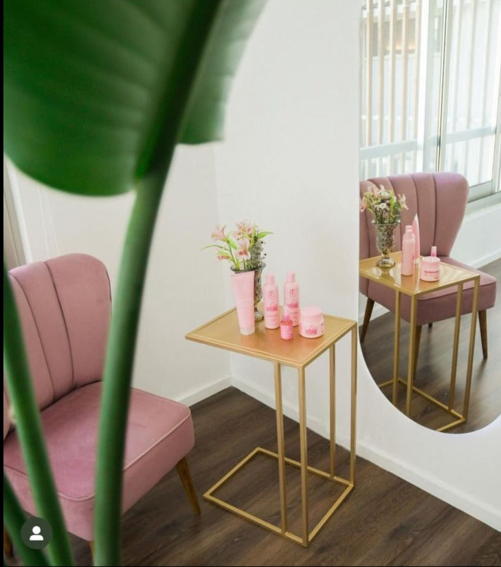 Butaca tapizada rosa con respaldo en forma de pétalos y patas de madera. Ideal como sillón decorativo o infantil para espacios modernos.