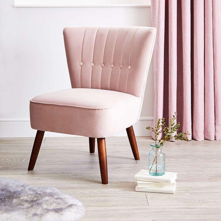 Butaca pequeña tapizada en rosa con respaldo vertical y patas cónicas. Diseño minimalista ideal para niños o espacios reducidos.