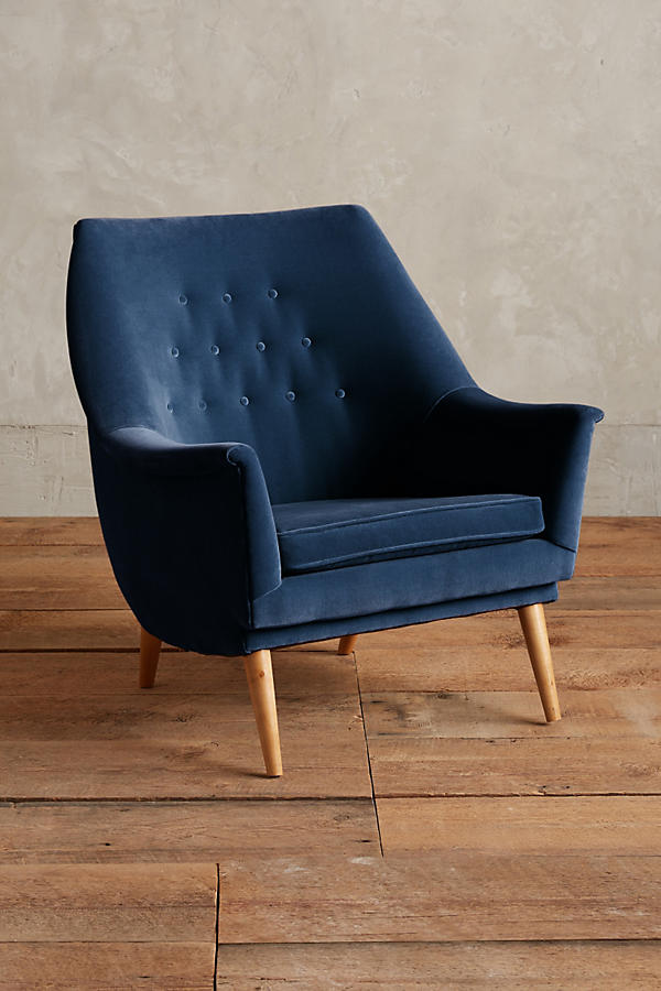 Sillón individual tapizado en azul, de diseño retro con respaldo inclinado, asiento acolchado y patas de madera inclinadas estilo escandinavo.