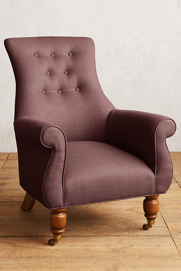 Sillón individual estilo clásico tapizado en rosa, con respaldo alto capitoné, apoyabrazos curvos y patas torneadas de madera.