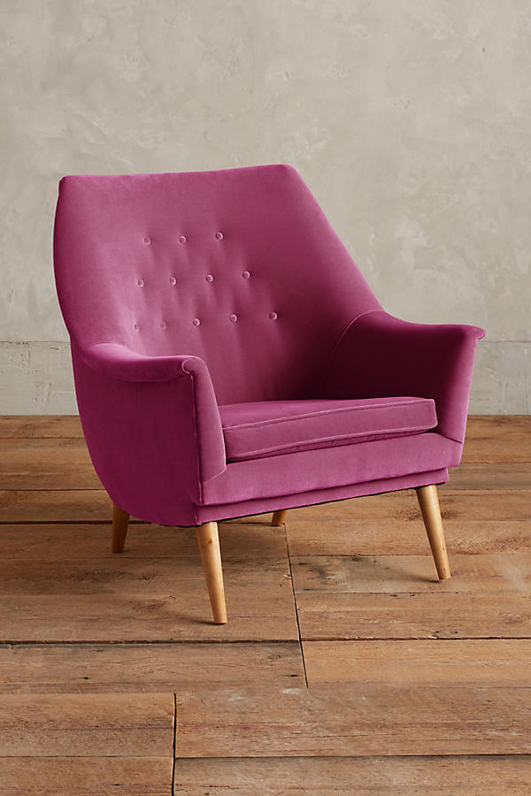 Sillón individual tapizado en magenta, de diseño retro con respaldo inclinado, asiento acolchado y patas de madera inclinadas estilo escandinavo.