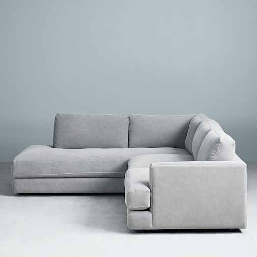 Sillón esquinero amplio en gris claro, almohadones grandes y asiento profundo. Confort máximo en estilo contemporáneo.