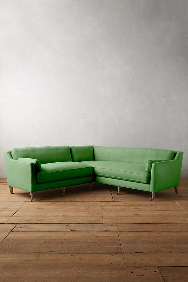 Sillón esquinero de diseño liviano en verde, estructura baja y líneas minimalistas. Ideal para ambientes femeninos y luminosos.