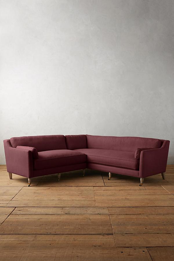 Sillón esquinero de diseño liviano en violeta, estructura baja y líneas minimalistas. Ideal para ambientes femeninos y luminosos.