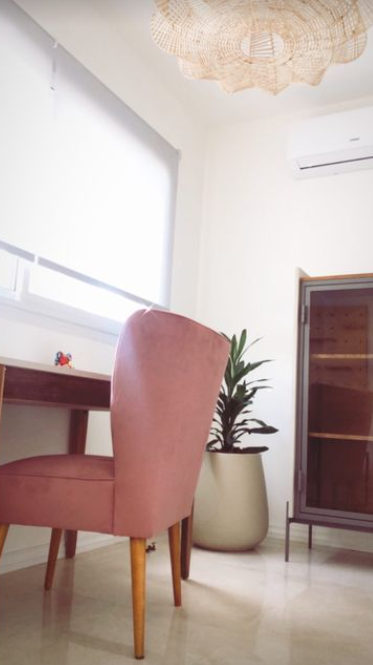 Butaca tapizada rosa con respaldo en forma de pétalos y patas de madera. Ideal como sillón decorativo o infantil para espacios modernos.