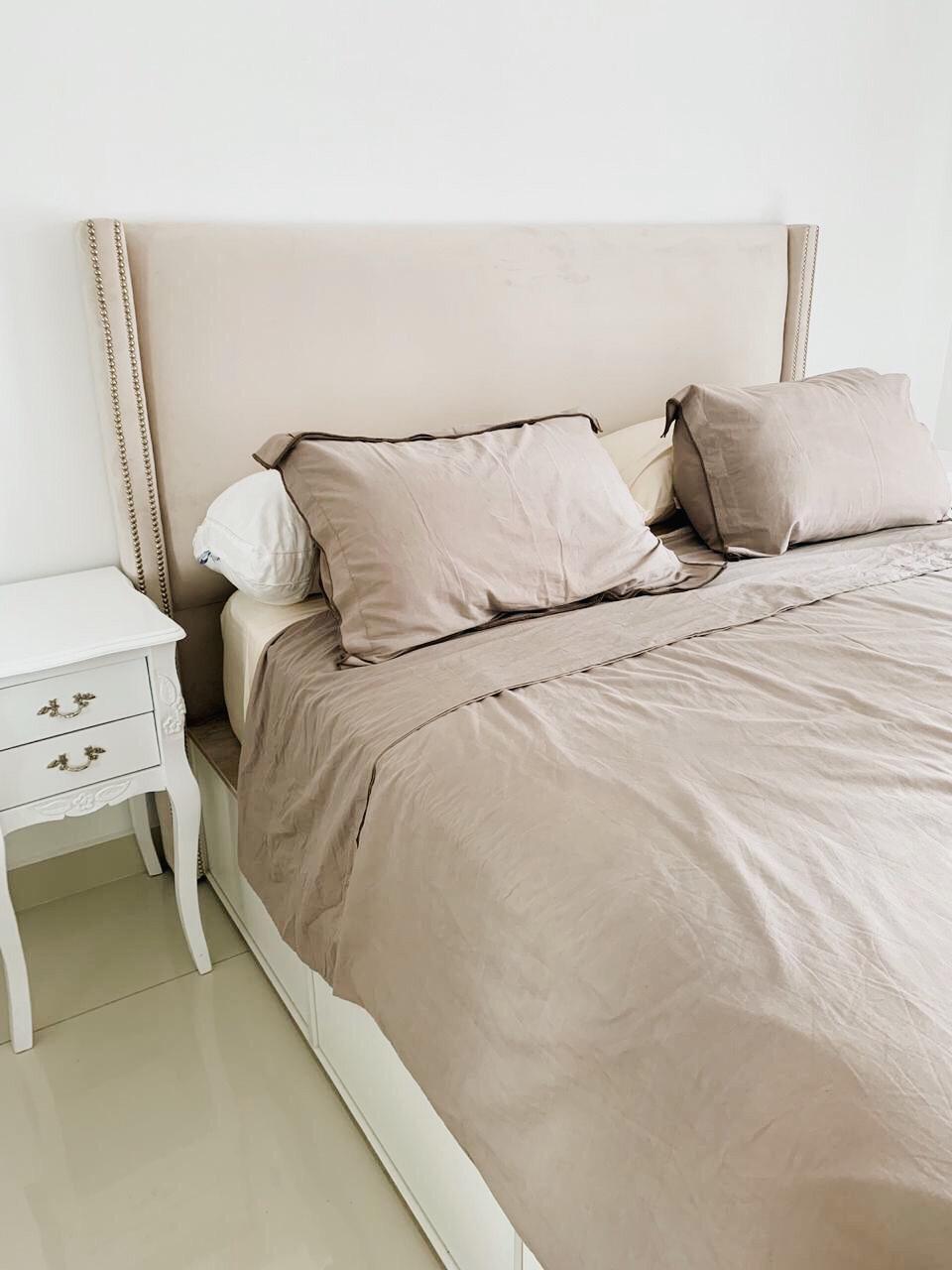 Mesa de Luz Bailarina Gillis blanca junto a un Respaldo Emmy beige con tachas, en el dormitorio de Milagros