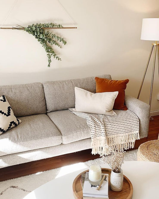 Sofá Viena tapizado en gris, ambientado en living con decoración natural - Tienda de Banquitos