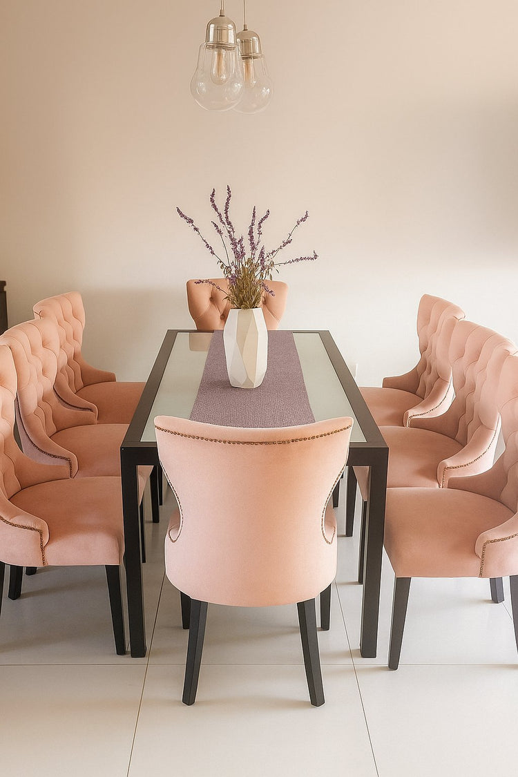 Sillas de comedor tapizadas en pana rosa con respaldo capitoné alrededor de una mesa en la casa de una clienta