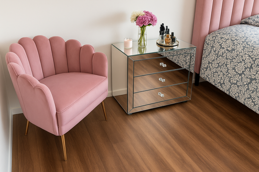 Sillón individual de diseño moderno con respaldo en forma de concha o pétalos, tapizado en terciopelo rosa suave. Sus patas delgadas de metal en acabado dorado realzan el estilo elegante y delicado de la pieza.