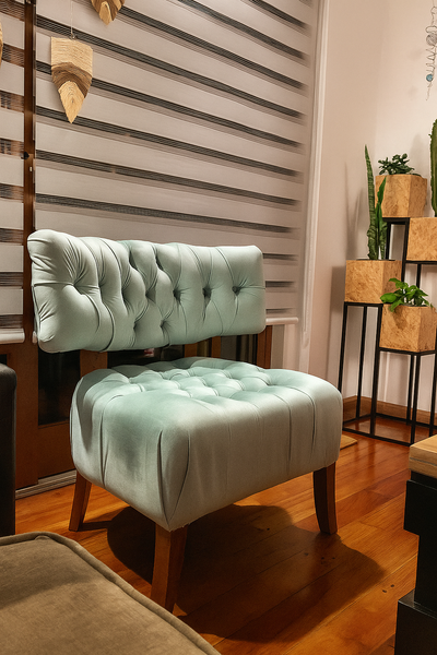Sillón individual tapizado en terciopelo color verde agua, con respaldo y asiento capitoné, patas de madera y diseño moderno ideal para espacios contemporáneos.