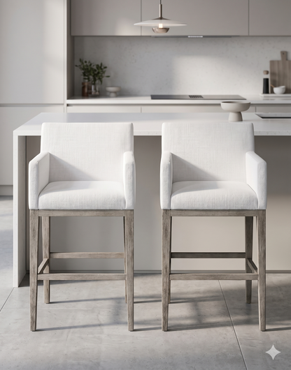 Banqueta alta de diseño contemporáneo con estructura de madera maciza en acabado natural. Presenta un asiento y respaldo integrado, tapizado en pana color claro con textura sutil. Incluye apoyapiés perimetral de madera para mayor estabilidad y confort