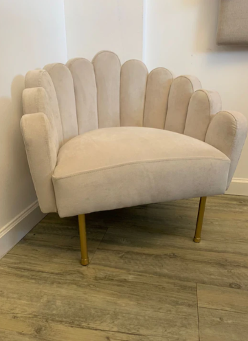 Sillón matero Mini Angie tapizado con respaldo y apoyabrazos de diseño ondulado y patas metálicas doradas.