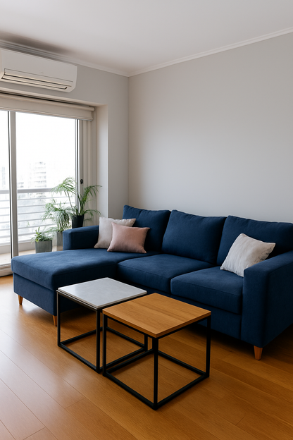 Este elegante sofá azul, con un diseño moderno y cómodo, es perfecto para agregar un toque de color y estilo a cualquier salón. Los cojines en tonos suaves, como el rosa y el gris, complementan su apariencia, ofreciendo tanto confort como diseño. La lámpara de pared y las mesas auxiliares de líneas simples y minimalistas añaden un toque contemporáneo, creando un ambiente acogedor y sofisticado. Ideal para quienes buscan un espacio moderno y funcional.