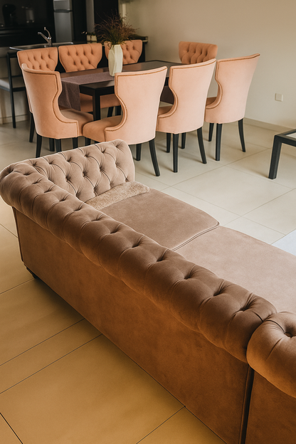 Juego de comedor moderno con mesa rectangular negra de tapa de vidrio y ocho sillas tapizadas en terciopelo rosa pastel, con respaldo capitoné y patas negras