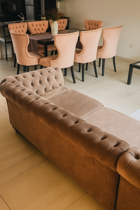 Juego de comedor moderno con mesa rectangular negra de tapa de vidrio y ocho sillas tapizadas en terciopelo rosa pastel, con respaldo capitoné y patas negras