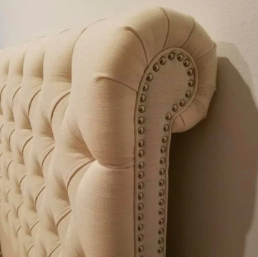Respaldo de cama modelo Chesterfield con capitoné artesanal y botones, tapizado en tela suave, estilo clásico y elegante para realzar cualquier dormitorio.


