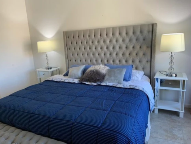 Respaldo de cama modelo Emmy tapizado liso con bordes rectos y acolchado cómodo, ideal para dormitorios versátiles y elegantes.