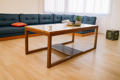 Gran sillón esquinero de diseño contemporáneo, tapizado en tela azul petróleo con múltiples respaldos mullidos que brindan comodidad. Su formato amplio y lineal se extiende a lo largo de la pared, convirtiéndose en la pieza protagonista del living y aportando un contraste elegante frente al piso de madera clara y la luz natural que entra desde las ventanas.
