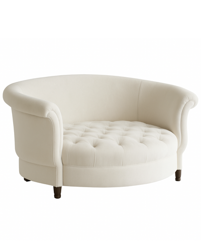Sillón redondo de estilo elegante en color crema, con respaldo curvo envolvente, apoyabrazos enrollados y asiento capitoné, patas cortas de madera.