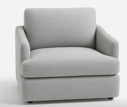 Sillón individual color gris con diseño moderno, apoyabrazos curvos y respaldo acolchado.