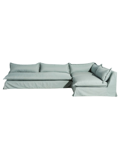 Sillón esquinero grande en lino gris claro con respaldo bajo, almohadones sueltos y chaise longue. Diseño descontracturado y moderno.