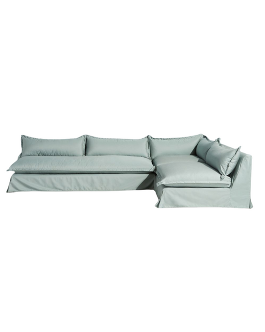 Sillón esquinero grande en lino gris claro con respaldo bajo, almohadones sueltos y chaise longue. Diseño descontracturado y moderno.