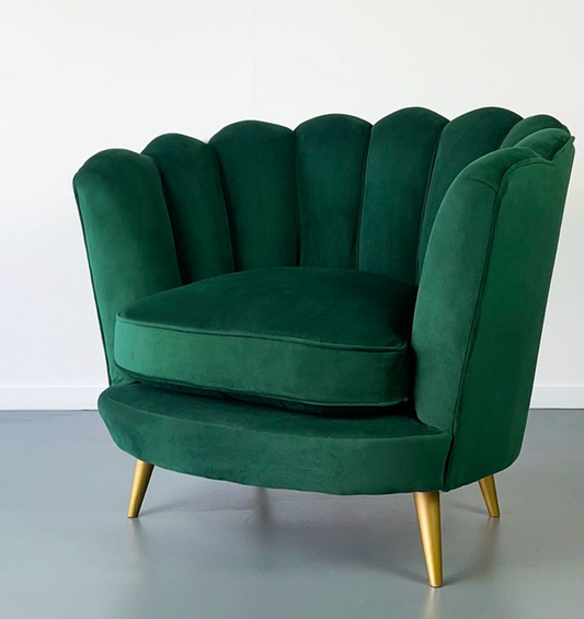 Sillón Florencia de un cuerpo en ambiente cálido, junto a cortinas de lino y mesa ratona de madera clara, tapizado en tono crudo, respaldo curvo y almohadón decorativo